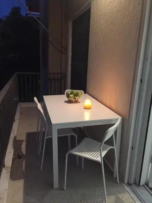 a white table and chairs on a balcony at Faliro Apartments Next To The Beach in Athens