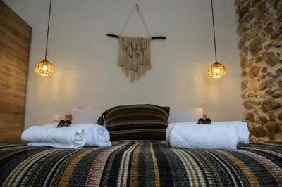 a bedroom with two beds with towels and lights at Deus Apartments_ Athens Airport in Spáta