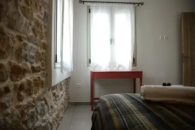 a bedroom with a bed and two windows at Deus Apartments_ Athens Airport in Spáta
