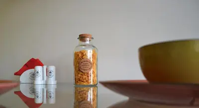 a bottle of seeds on a table next to a bowl at Deus Apartments_ Athens Airport in Spáta