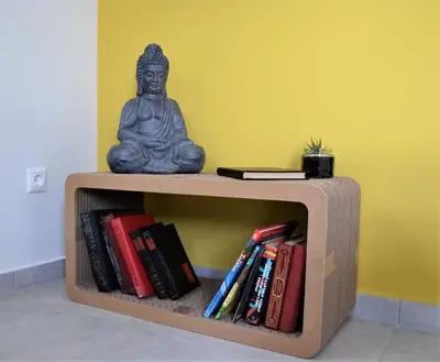 a buddha statue sitting on a book shelf with books at Deus Apartments_ Athens Airport in Spáta