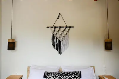 a chandelier hanging over a bed with pillows at Deus Apartments_ Athens Airport in Spáta