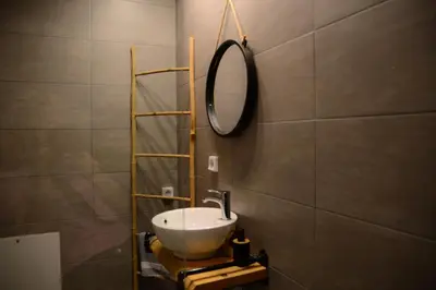 a bathroom with a sink and a mirror on the wall at Deus Apartments_ Athens Airport in Spáta