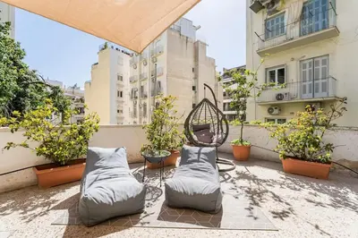 a patio with two beds and potted plants on a balcony at Amazing 3BDR Apt with Unique Roof Garden in Plaka in Athens
