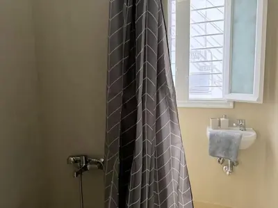 a bathroom with a shower curtain and a sink at Amazing 3BDR Apt with Unique Roof Garden in Plaka in Athens
