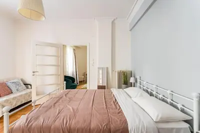 a white bedroom with a bed and a couch at Amazing 3BDR Apt with Unique Roof Garden in Plaka in Athens