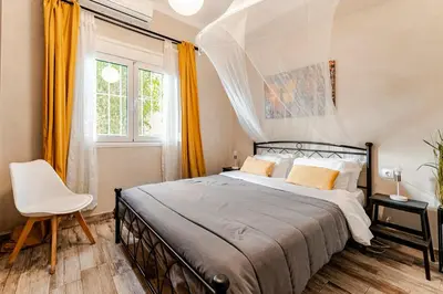 a bedroom with a bed and a chair and a window at Amazing House with Jacuzzi and Huge PVT Garden in Athens