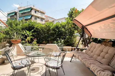 a patio with a couch and a table and chairs at Amazing House with Jacuzzi and Huge PVT Garden in Athens