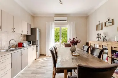 a kitchen with a table and chairs in a kitchen at Amazing House with Jacuzzi and Huge PVT Garden in Athens