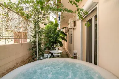 a hot tub in the courtyard of a building at Amazing House with Jacuzzi and Huge PVT Garden in Athens