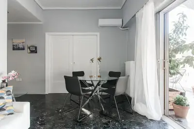 a dining room with a table and chairs at A Masterpiece in Plaka with Big Balcony and Acropolis View in Athens