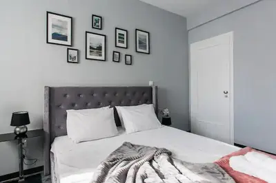a bedroom with a large bed with a gray headboard at A Masterpiece in Plaka with Big Balcony and Acropolis View in Athens