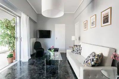 a living room with a white couch and a glass table at A Masterpiece in Plaka with Big Balcony and Acropolis View in Athens
