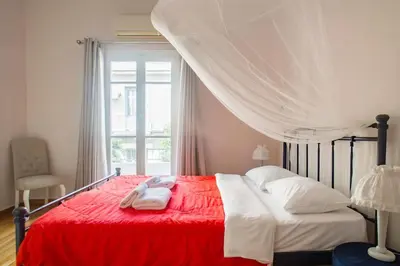a bedroom with a bed with a red blanket and a window at Splendid Full 5BDR/3bath/2kitchens Mansion in ATH in Athens