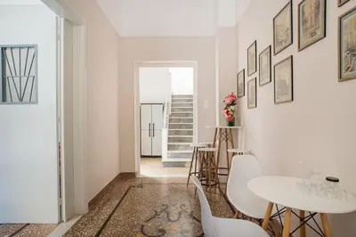a dining room with white walls and a table and chairs at Splendid Full 5BDR/3bath/2kitchens Mansion in ATH in Athens