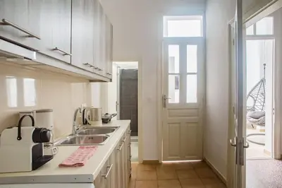 a white kitchen with a sink and a door at Splendid Full 5BDR/3bath/2kitchens Mansion in ATH in Athens