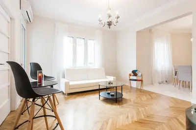 a living room with a white couch and a table at HIGHEND 2BDR Full APT/ IDEAL LOCATION (and Netflix) in Athens