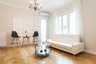 a living room with a white couch and a table at HIGHEND 2BDR Full APT/ IDEAL LOCATION (and Netflix) in Athens
