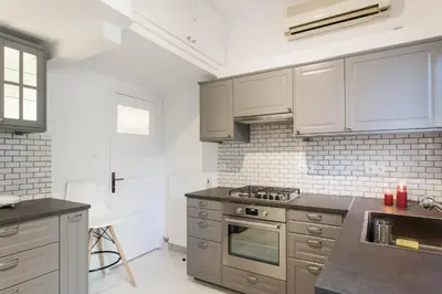 a kitchen with white cabinets and a stove top oven at HIGHEND 2BDR Full APT/ IDEAL LOCATION (and Netflix) in Athens
