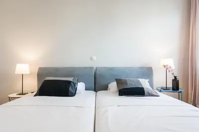 two beds sitting next to each other in a bedroom at HIGHEND 2BDR Full APT/ IDEAL LOCATION (and Netflix) in Athens