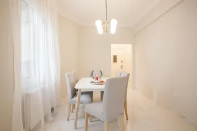 a white dining room with a white table and chairs at HIGHEND 2BDR Full APT/ IDEAL LOCATION (and Netflix) in Athens