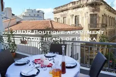 a table on a balcony with a view of a building at 2BDR Boutique Full Apt in Plaka (BIG BALCONY) in Athens