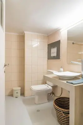 a bathroom with a toilet and a sink and a mirror at OpenAir HOT TUB/Big Balcony/Great Boutique Apt in Athens