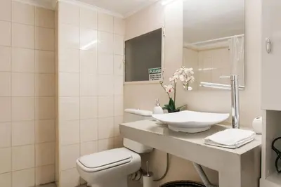 a bathroom with a sink and a toilet and a mirror at OpenAir HOT TUB/Big Balcony/Great Boutique Apt in Athens