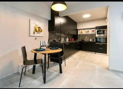 a kitchen with a table and chairs in a room at Romantic Jacuzzi Apartment in Athens