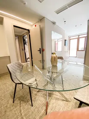 a glass table and a chair in a room at Royalty Hotel Athens in Athens
