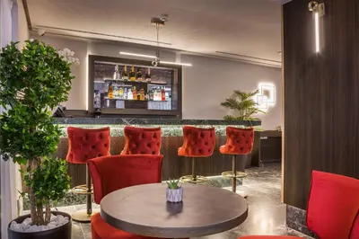 a bar with red chairs and a table and a counter at Royalty Hotel Athens in Athens