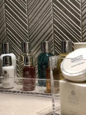 four bottles of perfume sitting on a shelf at Royalty Hotel Athens in Athens