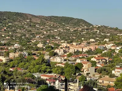 a town on a hill with houses and trees at WHOLE HOUSE NEAR THE BEACH WITH AMAZING VIEW in Kalívia Thorikoú