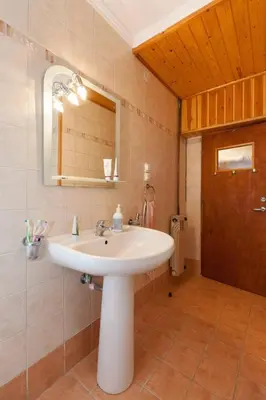 a bathroom with a white sink and a mirror at WHOLE HOUSE NEAR THE BEACH WITH AMAZING VIEW in Kalívia Thorikoú