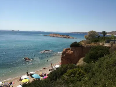 a beach with a bunch of people in the water at WHOLE HOUSE NEAR THE BEACH WITH AMAZING VIEW in Kalívia Thorikoú