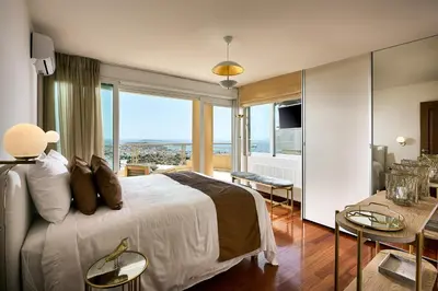 a hotel room with a bed and a large window at Grystal Green Properites in Athens