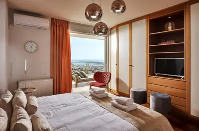 a bedroom with a large bed with a large window at Grystal Green Properites in Athens