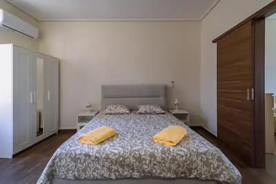 a bedroom with a large bed with two yellow pillows at Acropolis Comfy Home in the Heart of Athens for 4 by Filos Inc in Athens