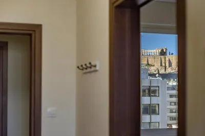 a mirror in a room with a view of a building at Acropolis Comfy Home in the Heart of Athens for 4 by Filos Inc in Athens