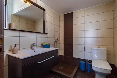a bathroom with a sink and a toilet and a mirror at Acropolis Comfy Home in the Heart of Athens for 4 by Filos Inc in Athens