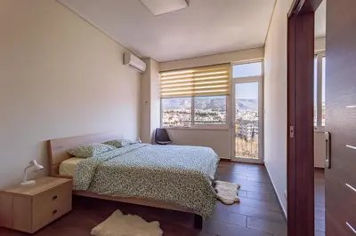 a bedroom with a bed and a large window at Acropolis Comfy Home in the Heart of Athens for 4 by Filos Inc in Athens