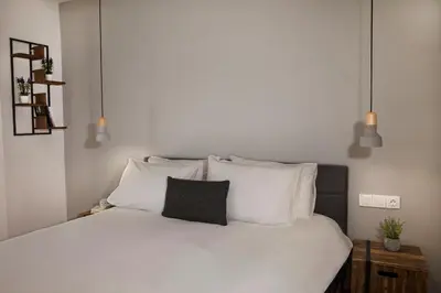 a bedroom with a bed with white sheets and pillows at Central Comfy Modern Flat 2 bedrooms 2 bathrooms in Athens