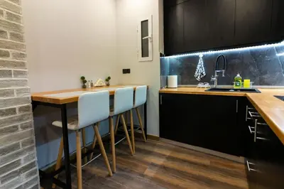 a kitchen with a wooden table and a sink at Double Romantic Suite in Athens