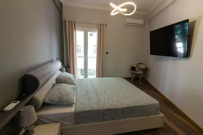 a bedroom with a bed and a flat screen tv at Double Romantic Suite in Athens