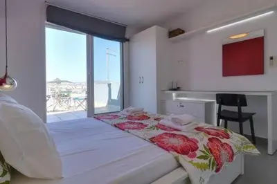 a bedroom with a bed with red flowers on it at Studio with private terrace and view of Acropolis! in Athens