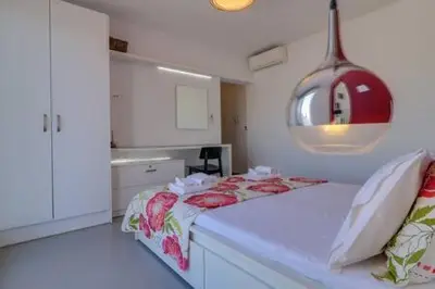 a small bedroom with a bed and a kitchen at Studio with private terrace and view of Acropolis! in Athens