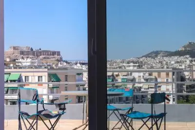 two chairs on a balcony with a view of a city at Studio with private terrace and view of Acropolis! in Athens