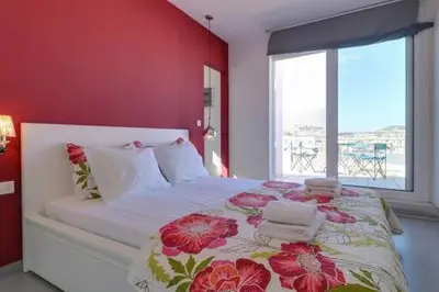 a bedroom with a large bed with a red wall at Studio with private terrace and view of Acropolis! in Athens