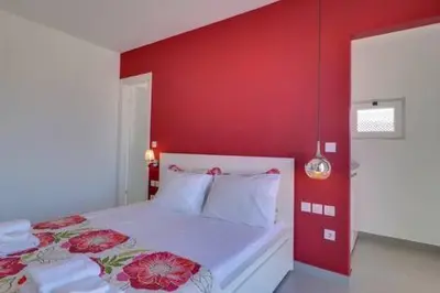 a bedroom with a red wall and a bed at Studio with private terrace and view of Acropolis! in Athens