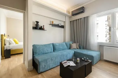 a living room with a blue couch and a table at COLORS Hotel Athens in Athens